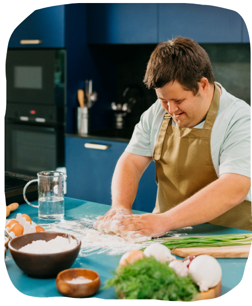 man with downs syndrome cooking in a kitchen